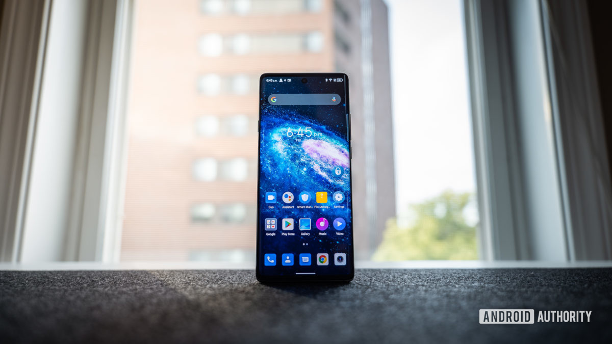 Front view of the TCL 20 Pro 5G on a table in front of a window, showing the screen and apps.