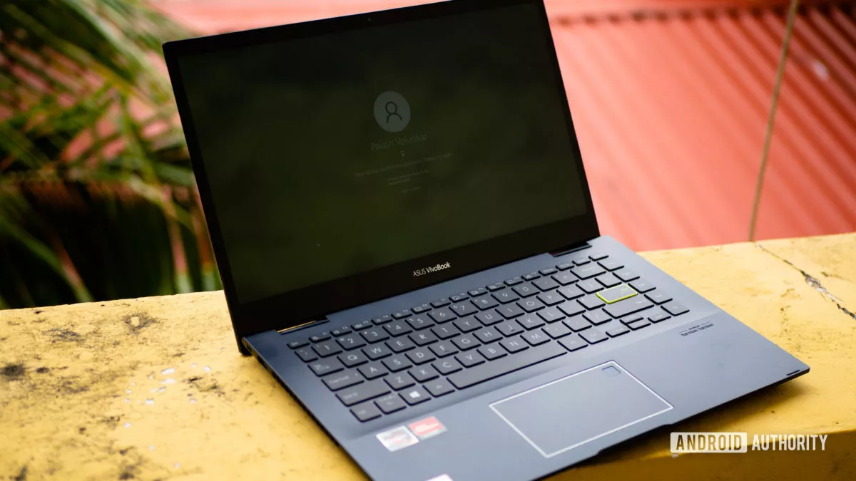 Asus VivoBook Flip 14 TM420 2021 review photo showing the laptop sitting on a yellow wall.