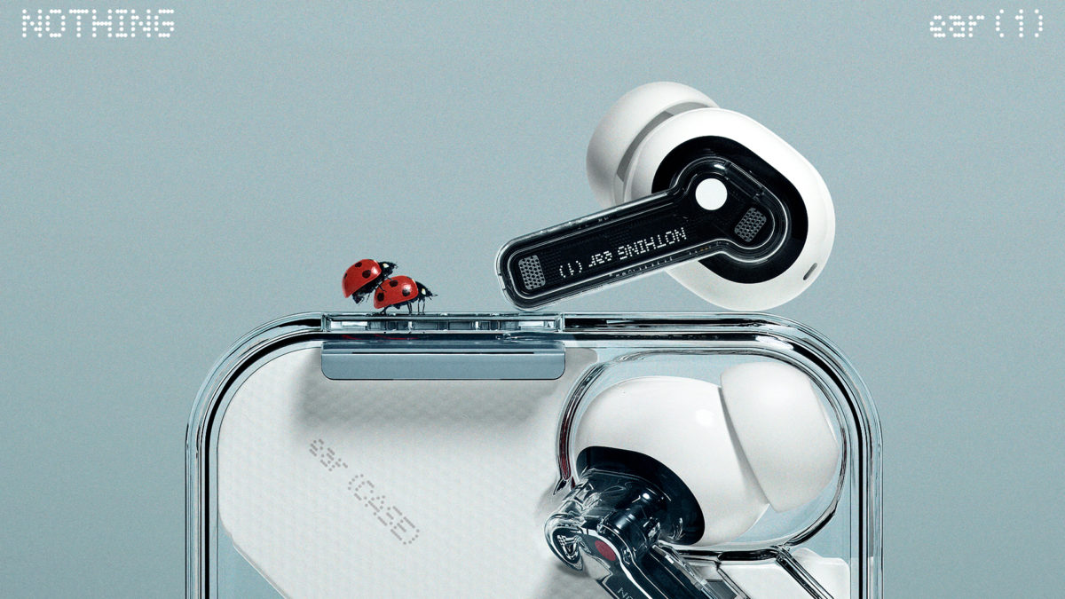 A close-up of the Nothing Ear 1 true wireless earbuds with one earbud on top of the case next to a pair of ladybugs.