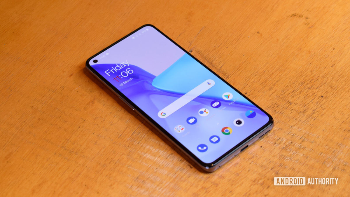 OnePlus 9 lying on a table showing the home screen.