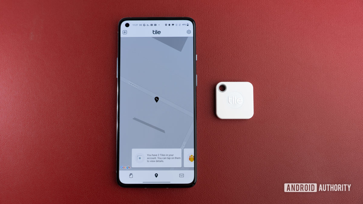 The Tile Mate Tracker next to a phone.