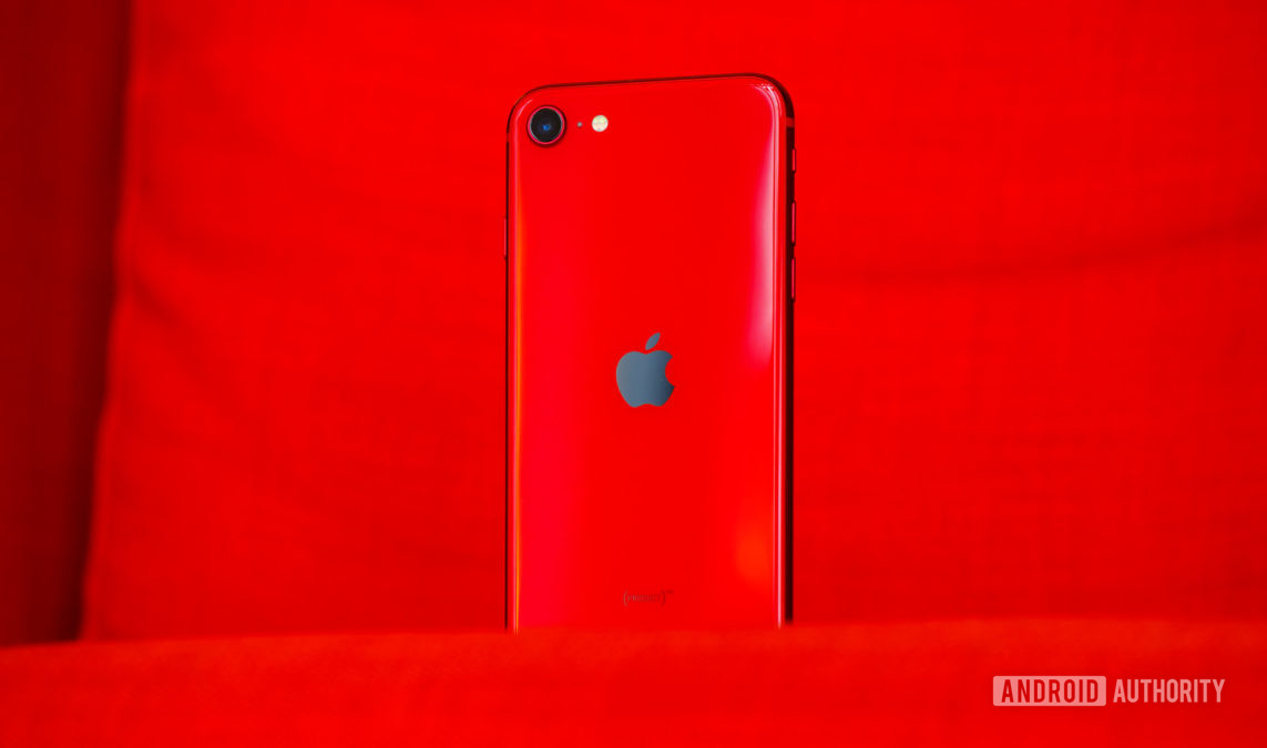 The iPhone SE in red showing the back Apple logo.