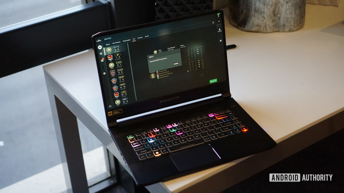 Acer Predator laptop on desk open showing RGB backlit keyboard.