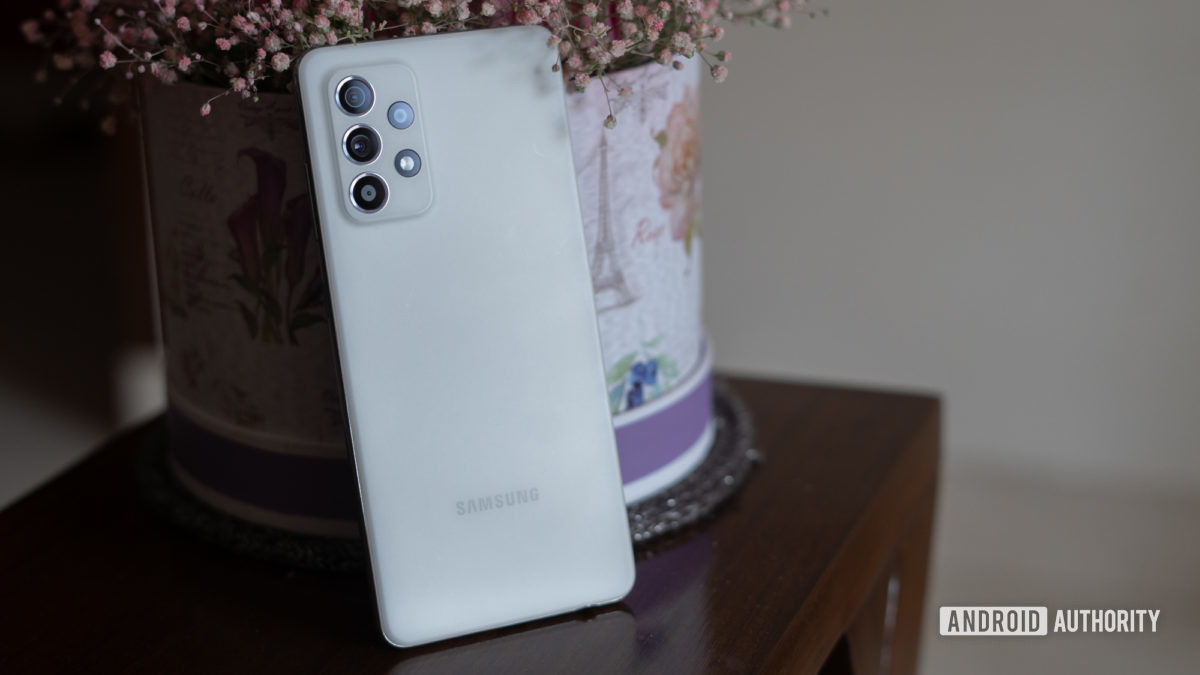 Samsung Galaxy A52s 5G angled up against flower pot rear view