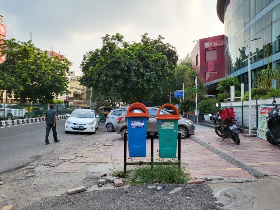 Samsung Galaxy Z Flip 3 sky and dynamic range showing a street scene with cars, motorbikes,, and colorful bins.