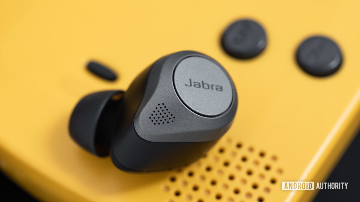 The Jabra Elite 85t noise cancelling true wireless earbuds microphone holes next to a Gameboy Color speaker grill.