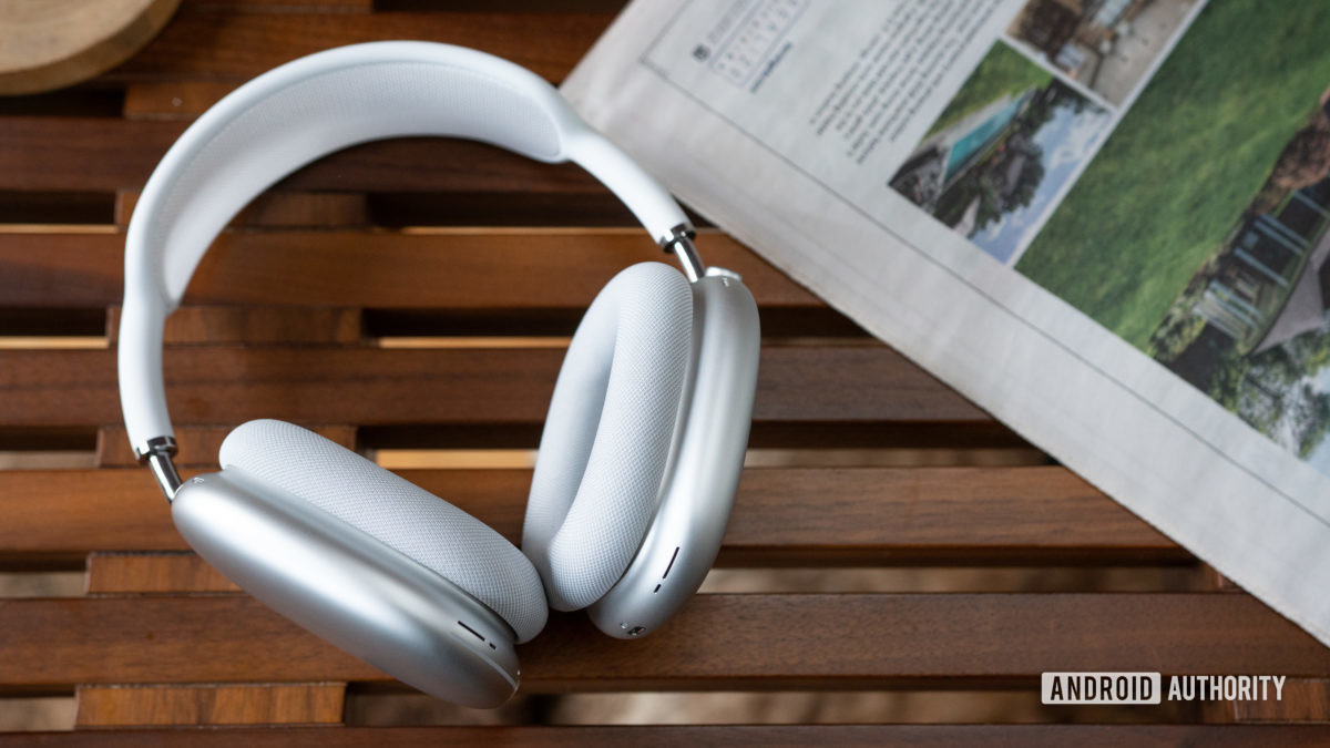 The Apple AirPods Max in white against a slatted wood surface.