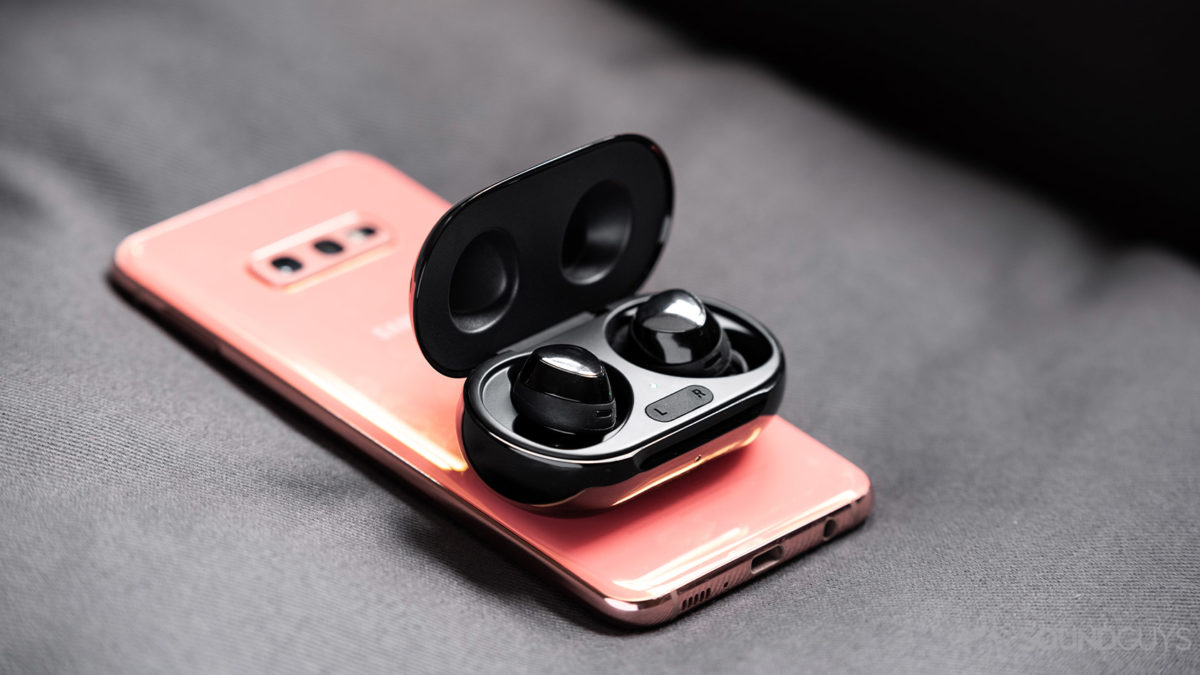 A photo of the Samsung Galaxy Buds Plus true wireless earbuds using wireless PowerShare atop a Samsung Galaxy S10e.