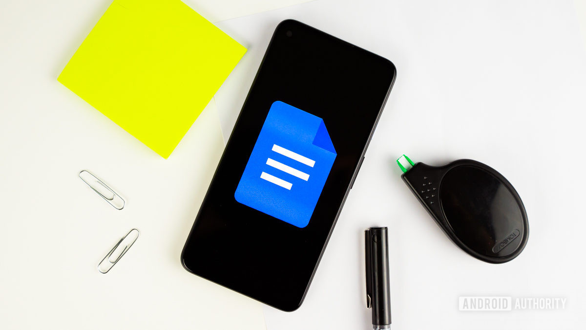 Google Docs logo on smartphone next to office gear stock photo 1