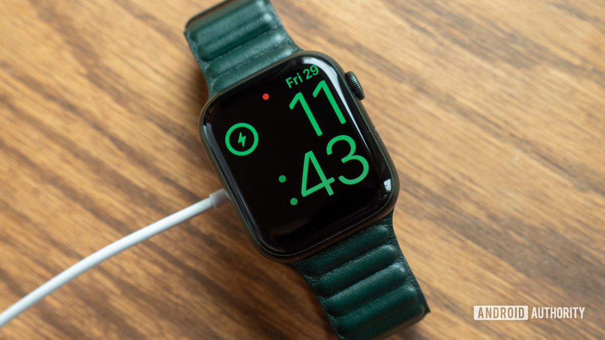 apple watch series 7 review charging on table battery life An image of the Apple Watch Series 7 on a table plugged in and charging