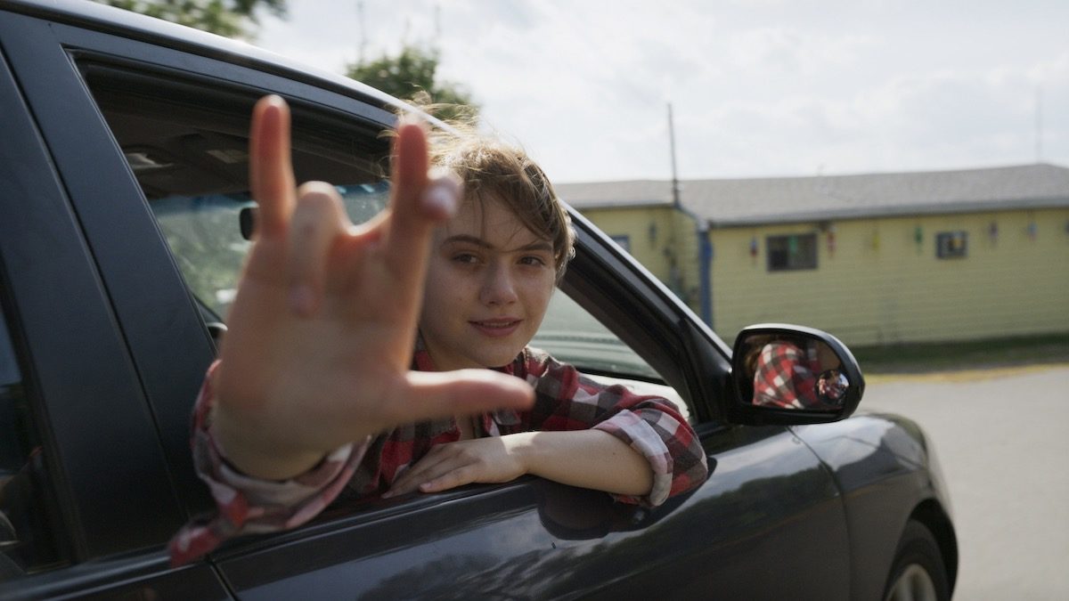 Emilia Jones signs from a car in CODA - best movies like CODA