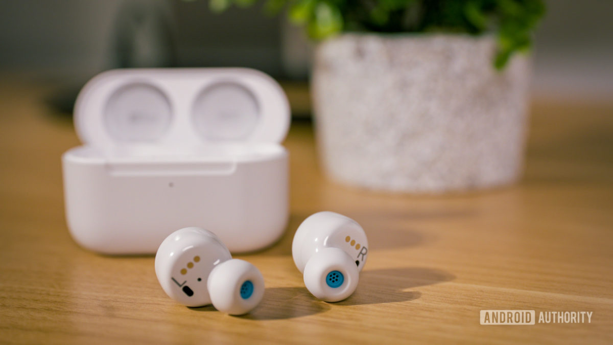 The Amazon echo buds (2nd Gen) in white on top of a wooden surface.