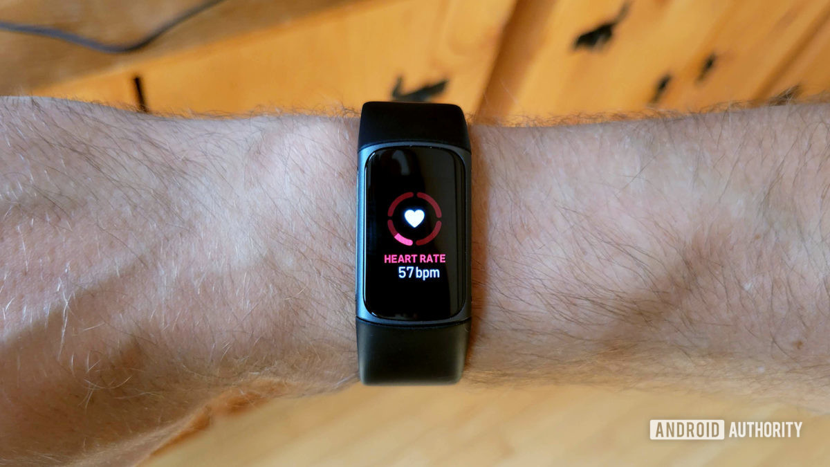 A Fitbit Charge 5 displays a user's heart rate.