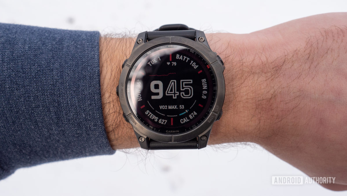 A Garmin Fenix 7 Sapphire Solar displays a clock face on a users wrist.