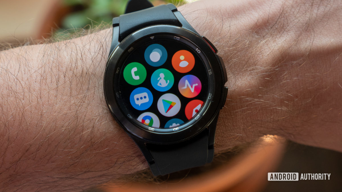 The Samsung Galaxy Watch 4 Classic on wrist showing the all apps screen containing Samsung Health, the Google Play Store, and others