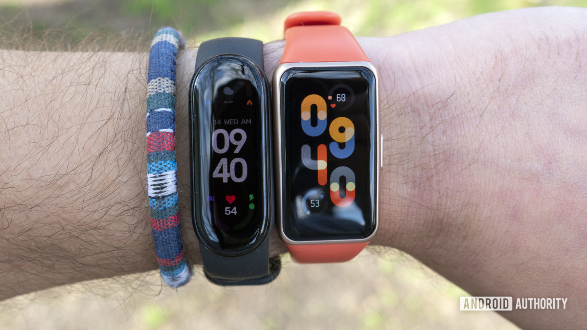 A user wears a Huawei Band 6 and a Xiaomi Mi Band 6 side by side.