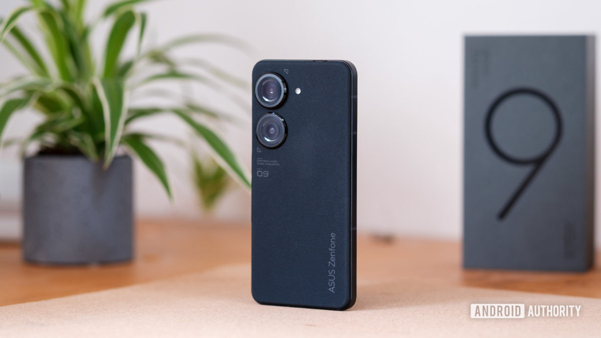 Asus Zenfone 9 review standing showing rear of phone and cameras, with the retail packaging in the background