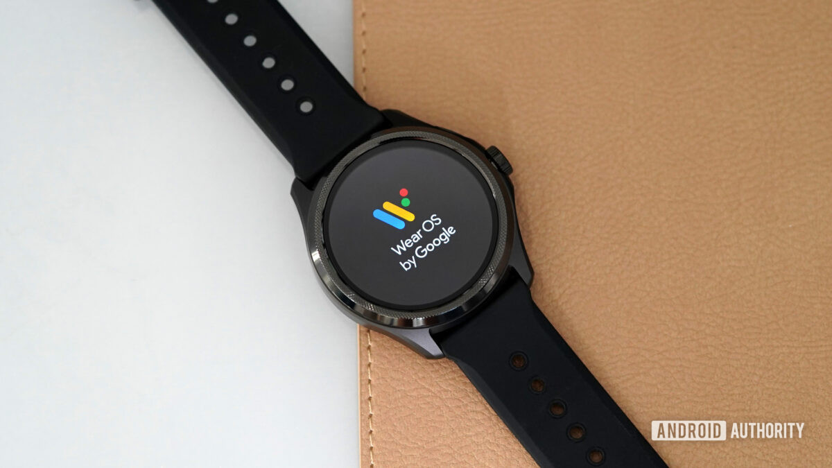 A TicWatch Pro 5 displays the Wear OS logo on screen.