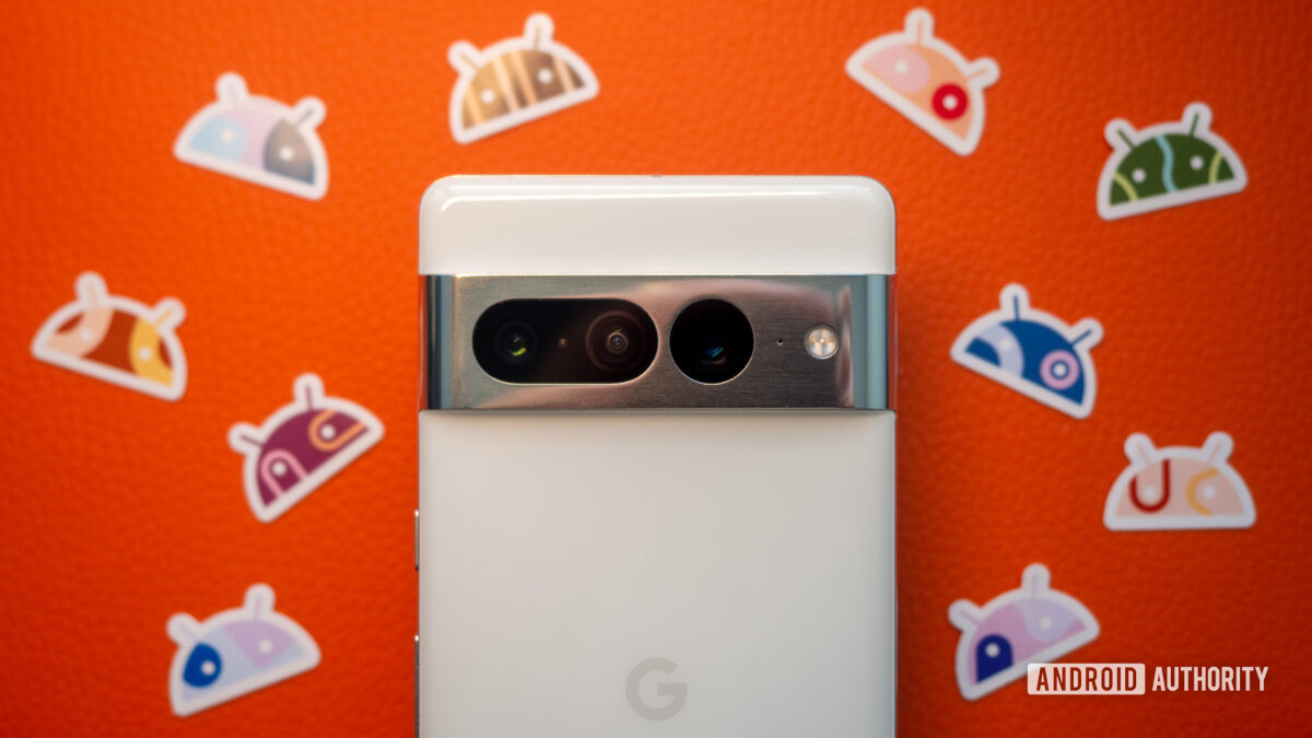 Google Pixel 7 Pro in white on an orange background with Android stickers next to it