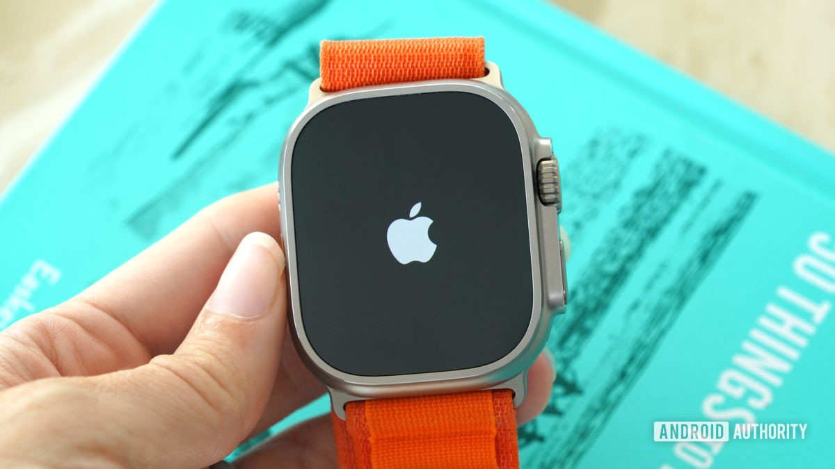 An Apple Watch Ultra in a user's hand displays the Apple logo.