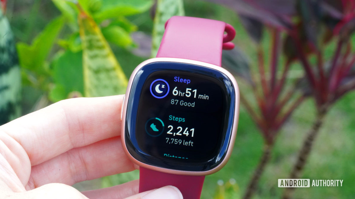 A Fitbit Versa 4 displays a user's sleep score and step count.