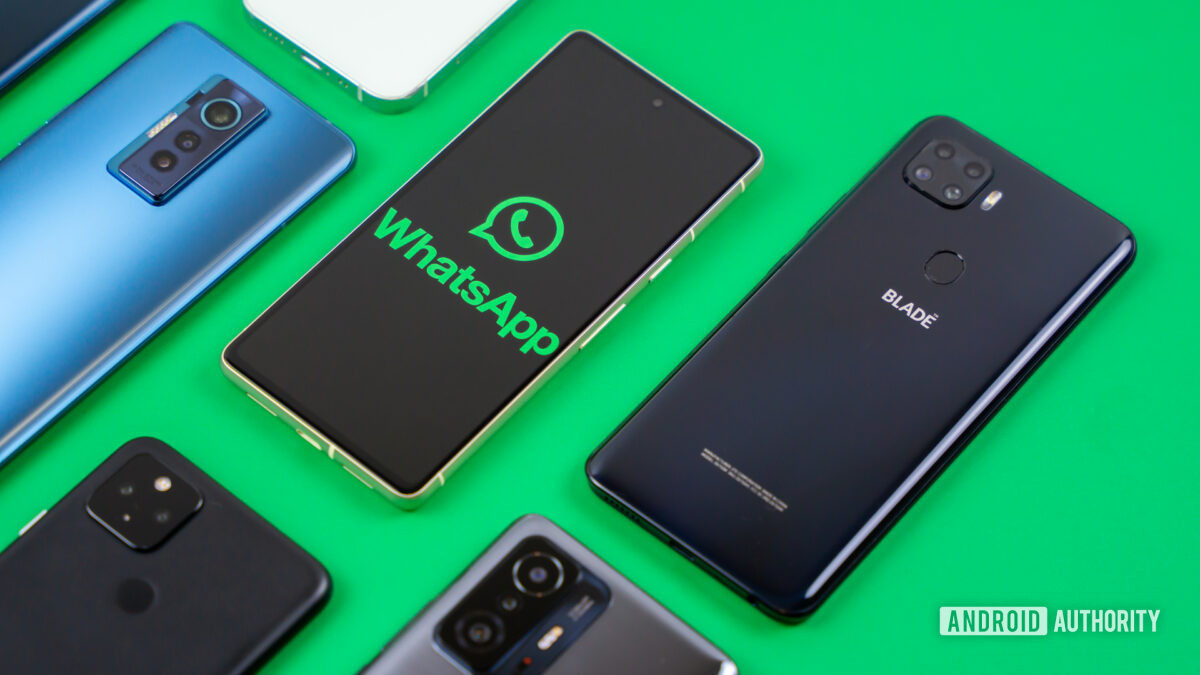 WhatsApp logo on smartphone next to other devices Stock photo 2