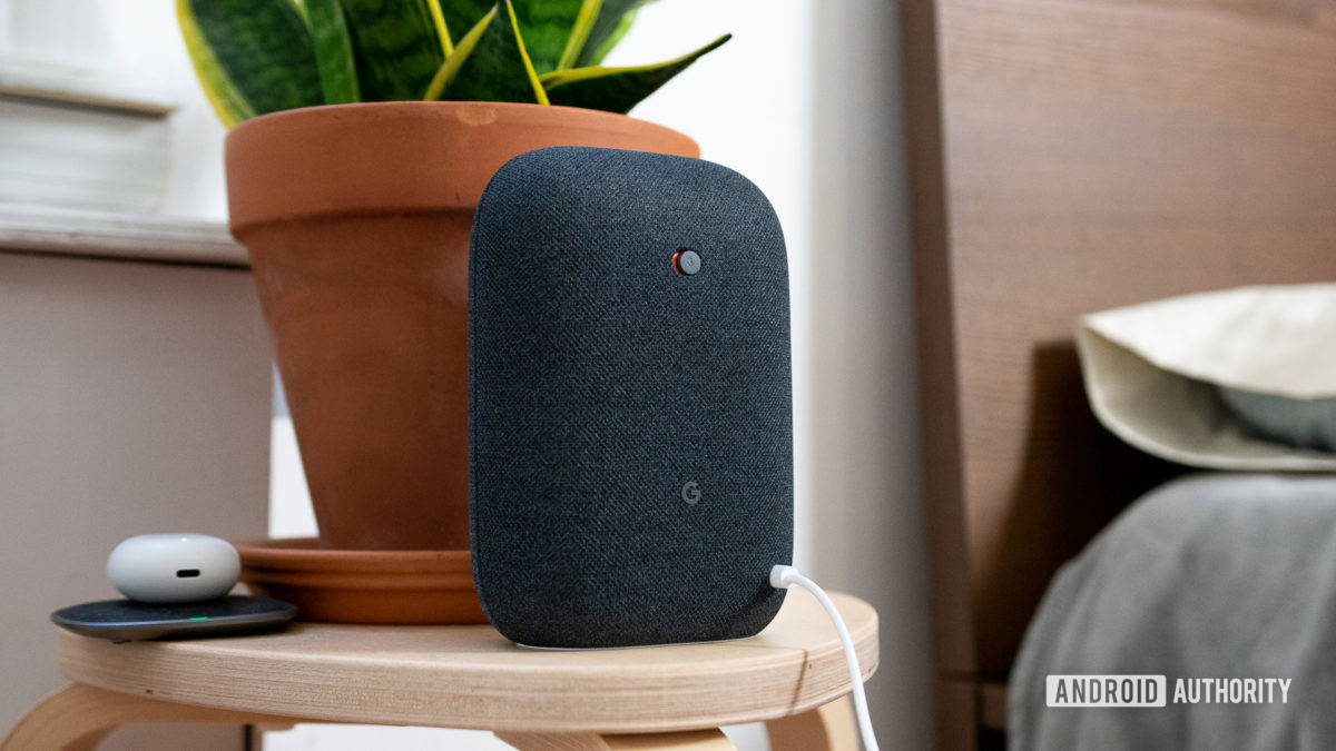 Google Nest Audio in black on nightstand next to bed