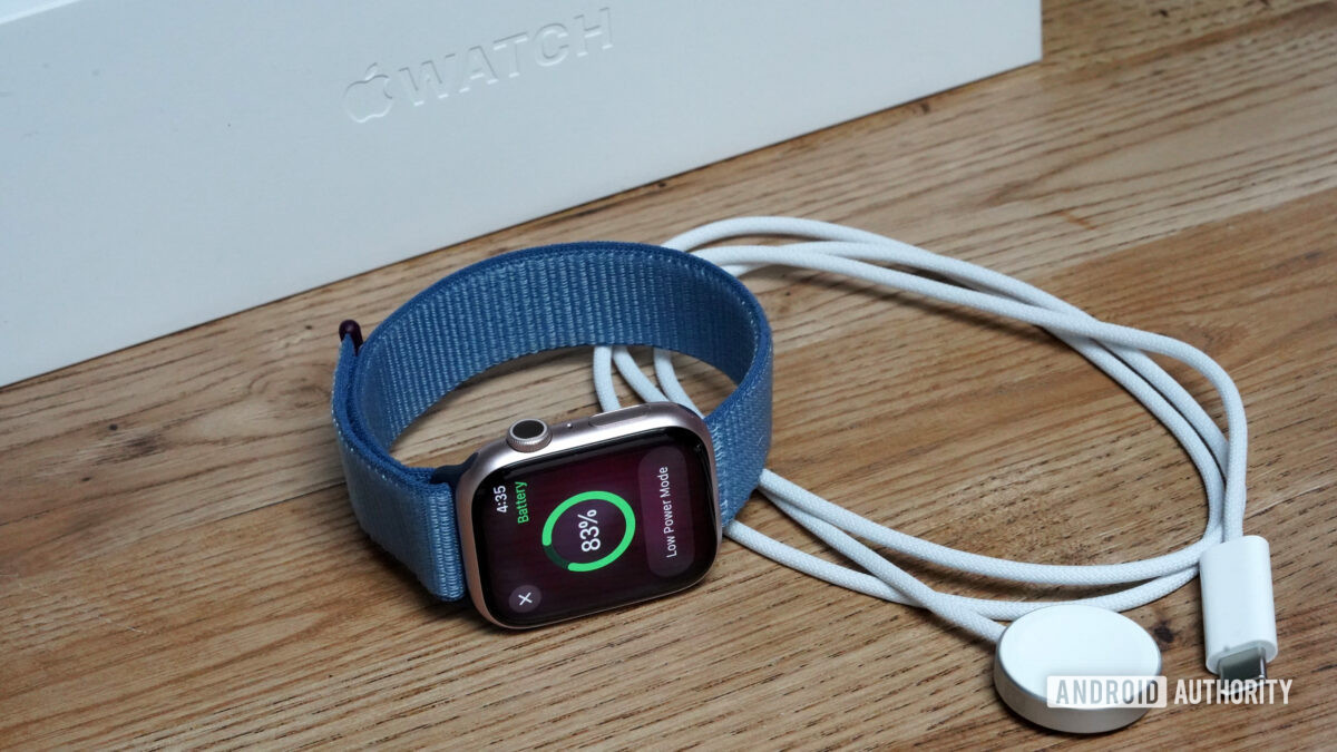 An Apple Watch Series 9 rests alongside its charger.