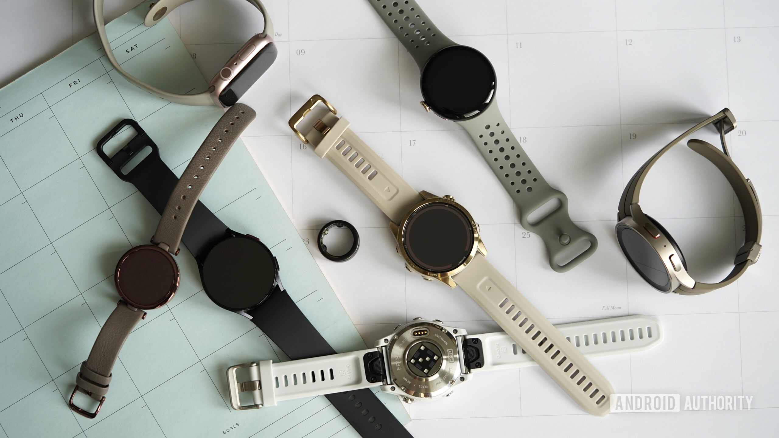 A variety of wearables rest on a collection of 2024 calendars.