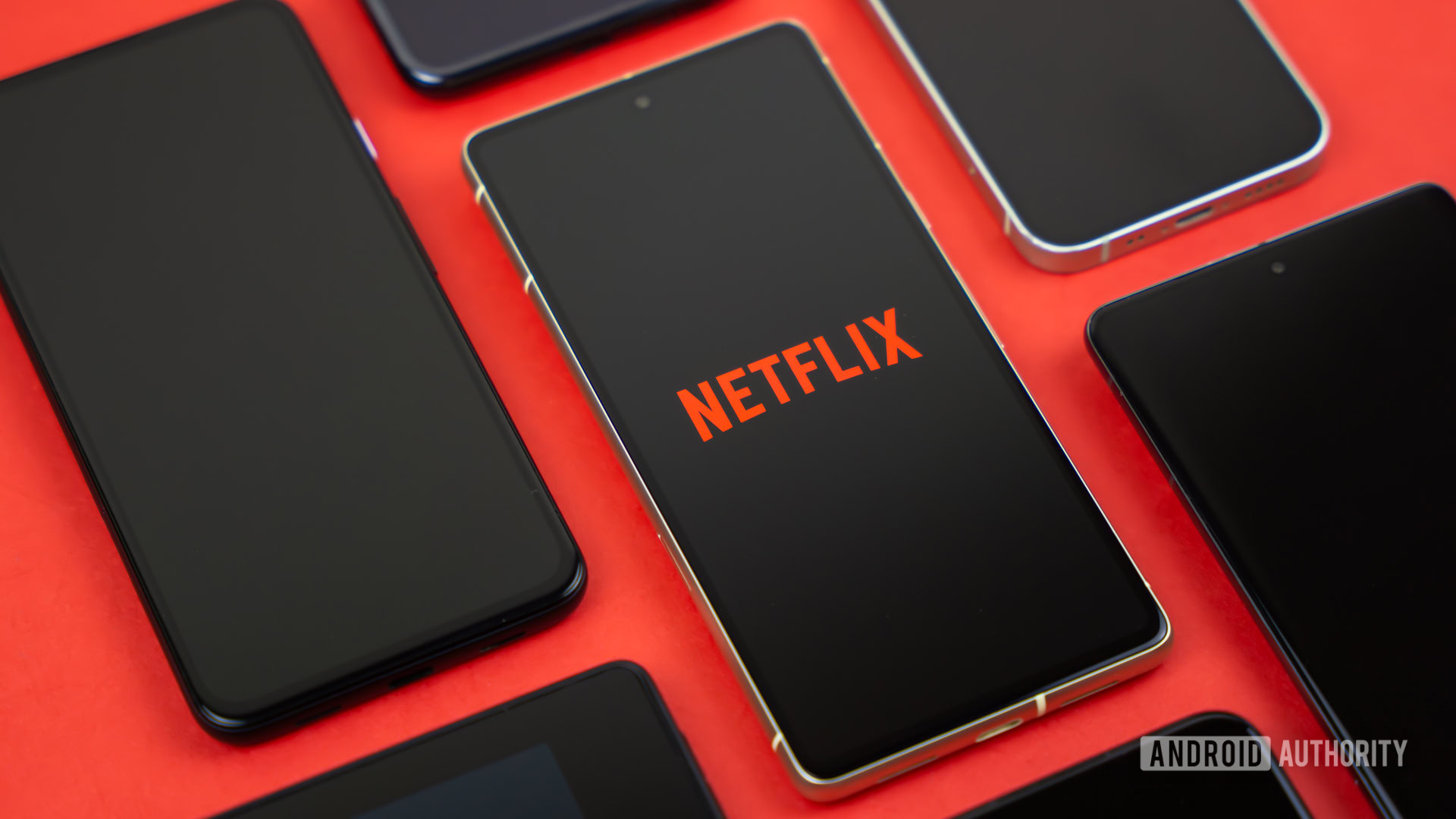 Netflix logo on smartphone, next to other devices stock photo (1)