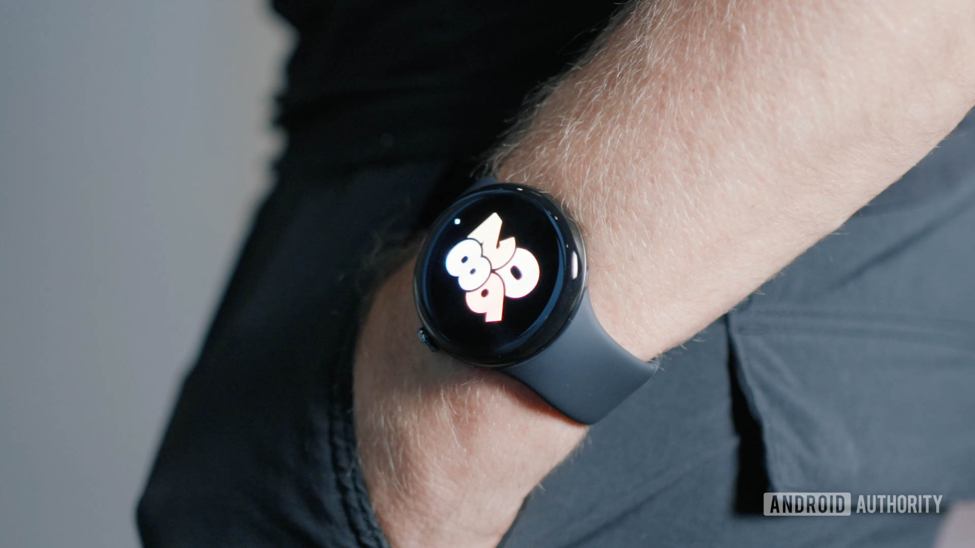 A man wearing a Google Pixel Watch 3 with his hands in his pocket.