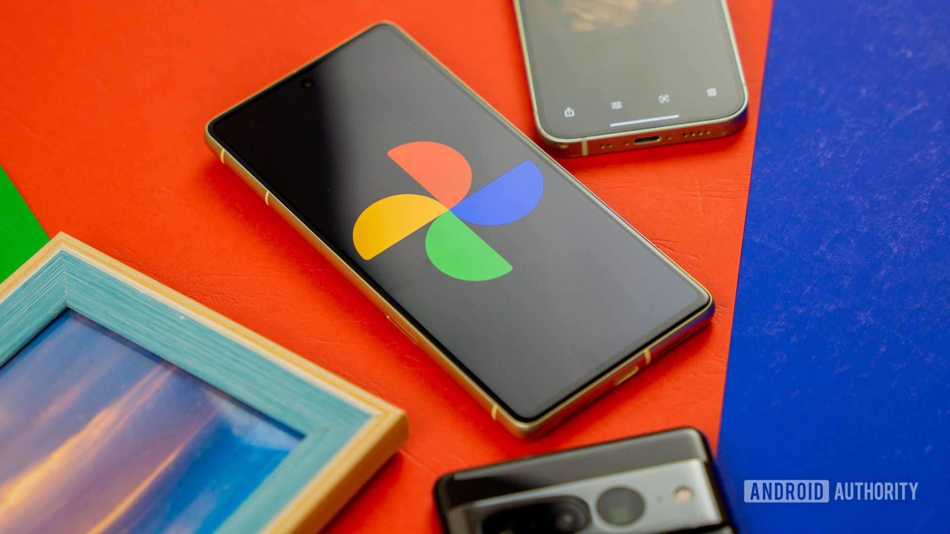 Google Photos logo on smartphone next to other devices and picture frame Stock photo 2