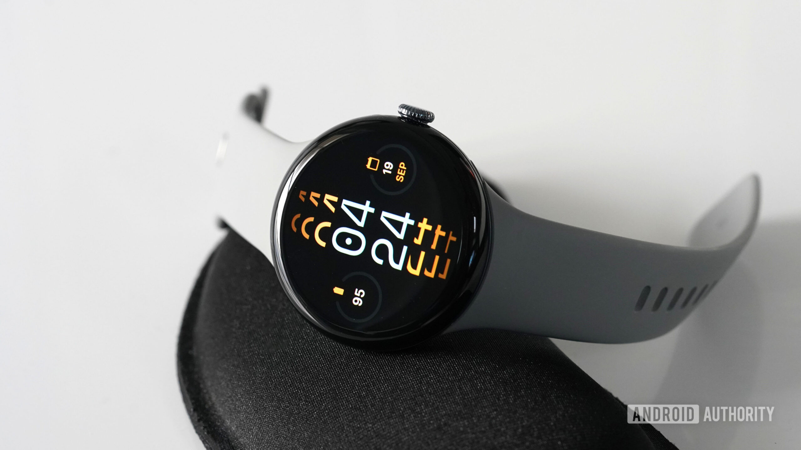 A Google Pixel Watch 3 displays the watch face Monospace.