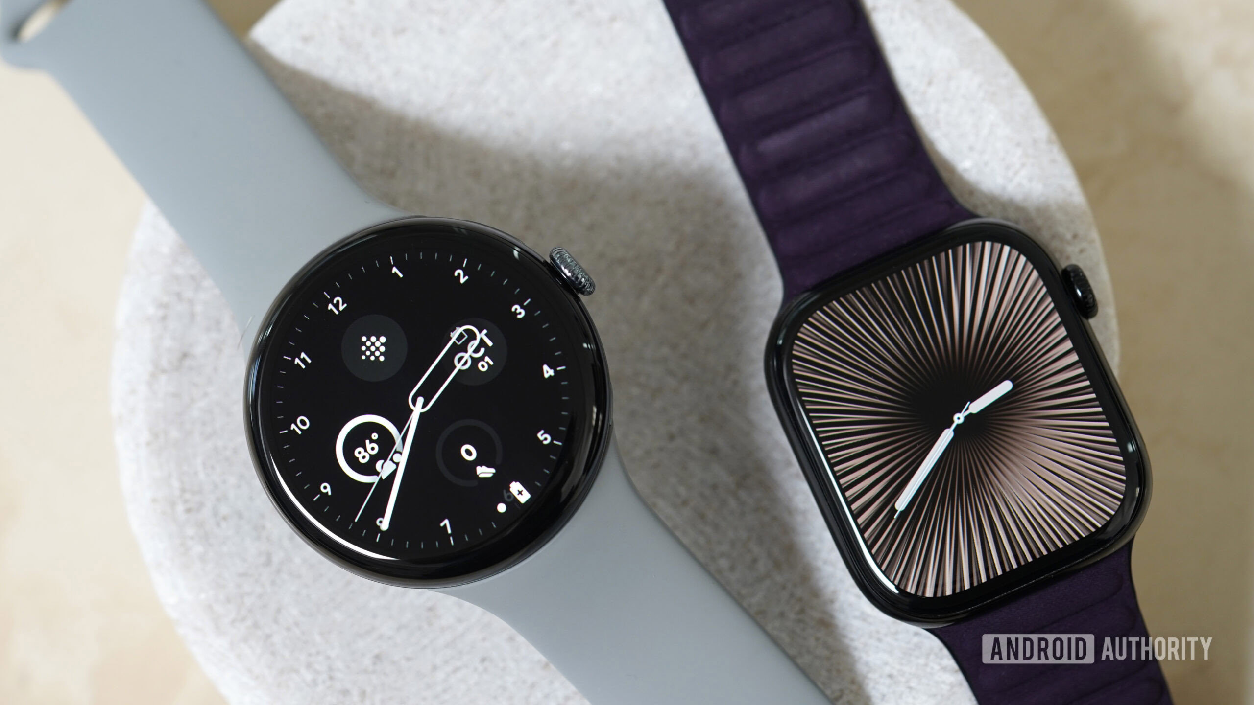 A Google Pixel Watch 3 and an Apple Watch Series 10 rest on a stone dish.