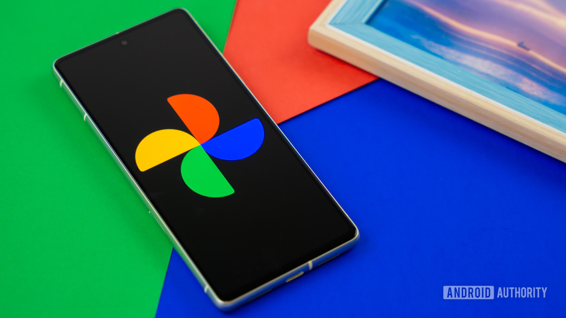 Google Photos logo on smartphone next to other devices and picture frame Stock photo 6 Gogole photos logo on smartphone next to other devices and picture frame Stock photo 6