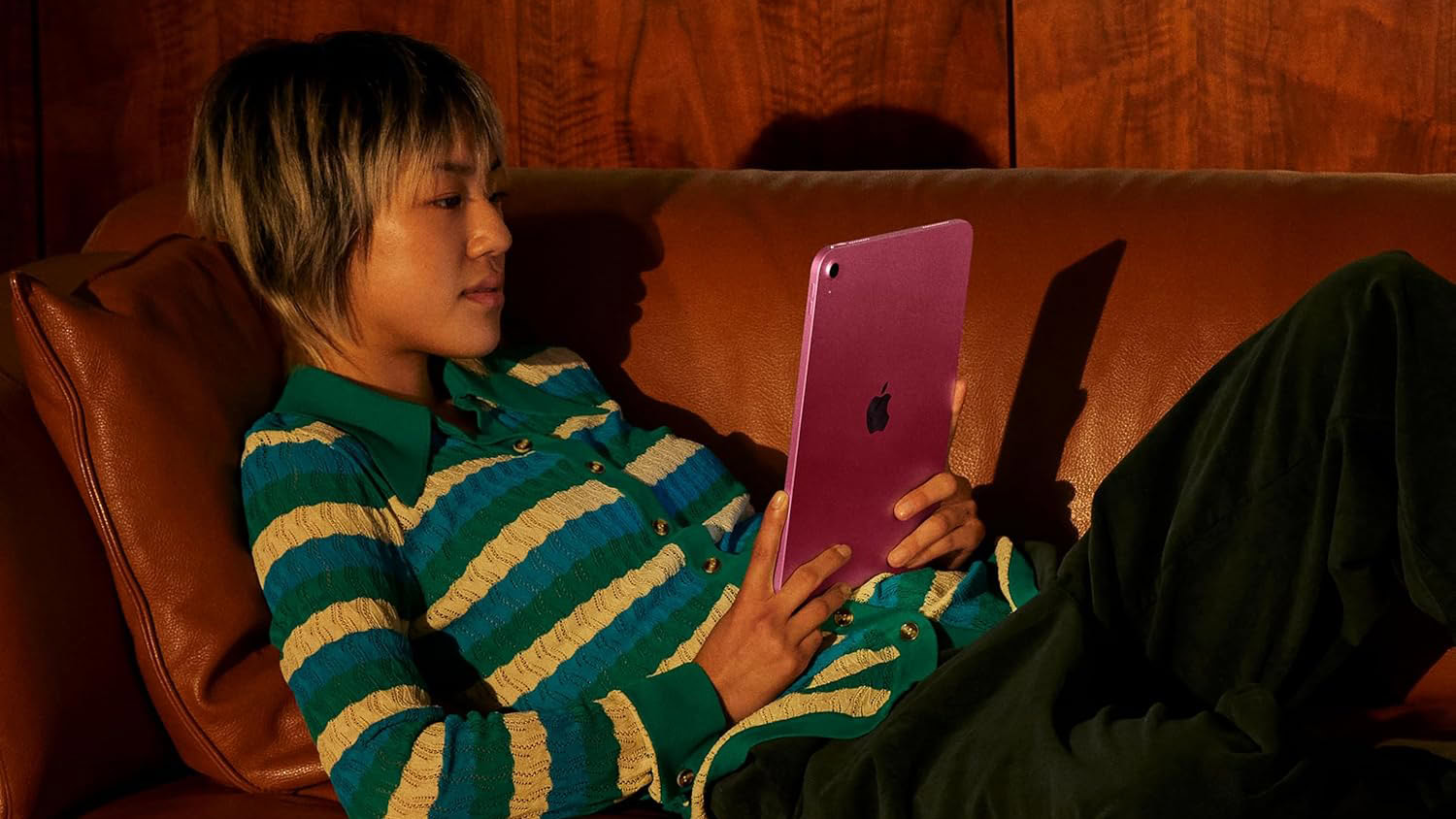 Apple iPad A16 being used by lady on couch Apple iPad A16 being used by lady on couch