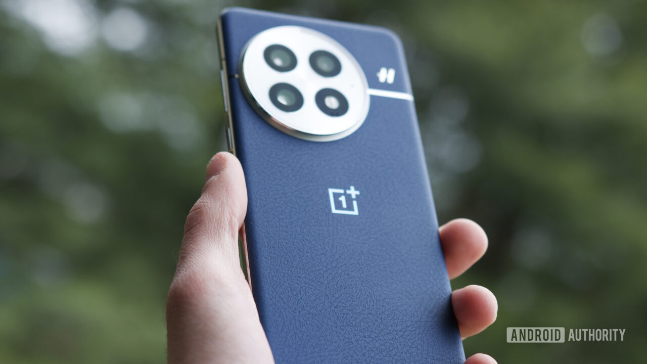 oneplus 13 outside blue Someone holding the OnePlus 13 outside.