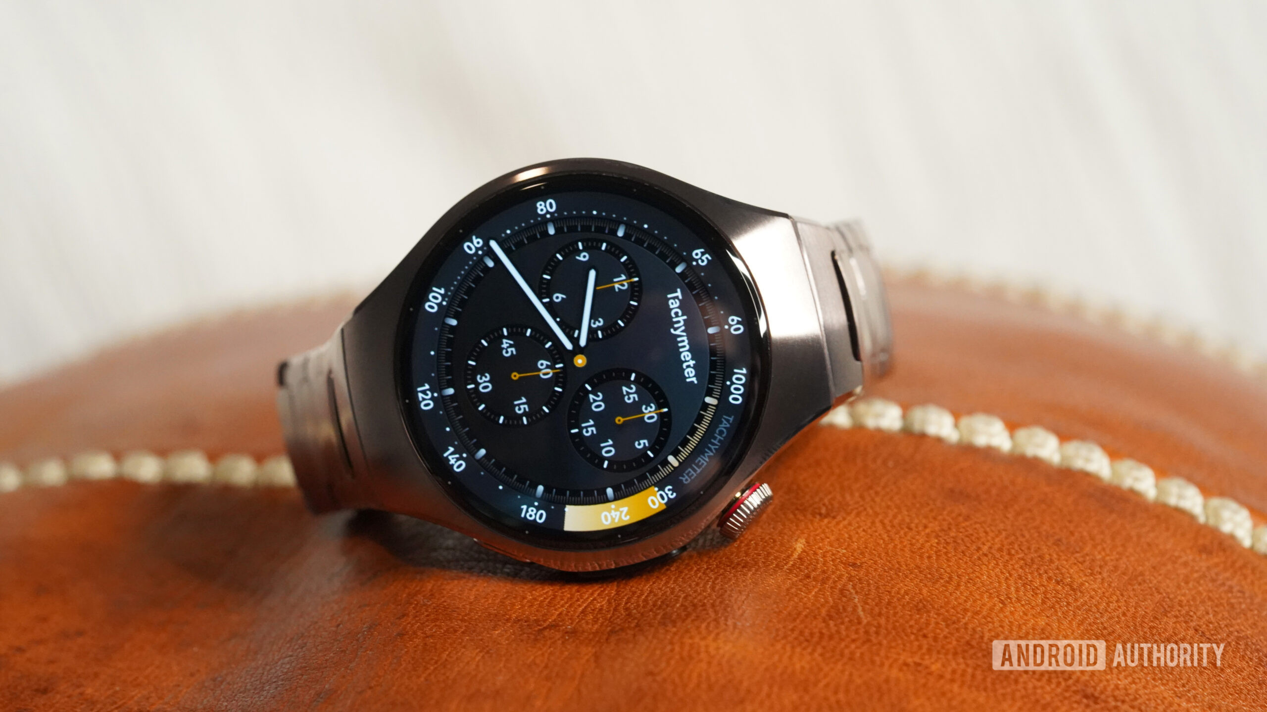 A Huawei Watch 5 rests on a leather surface.