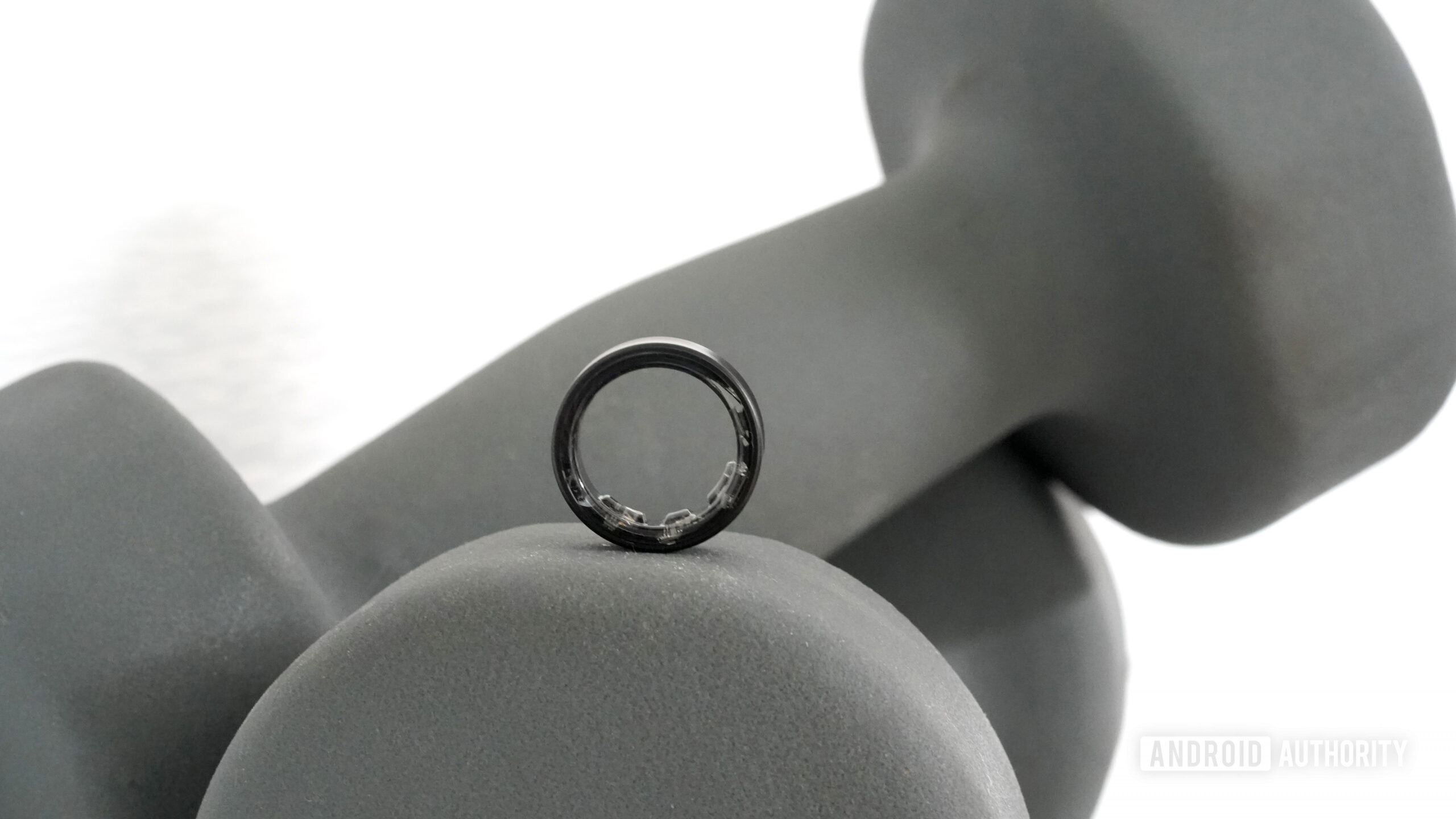 Samsung Galaxy Ring Weights A Samsung Galaxy Ring rests on a set of hand weights.