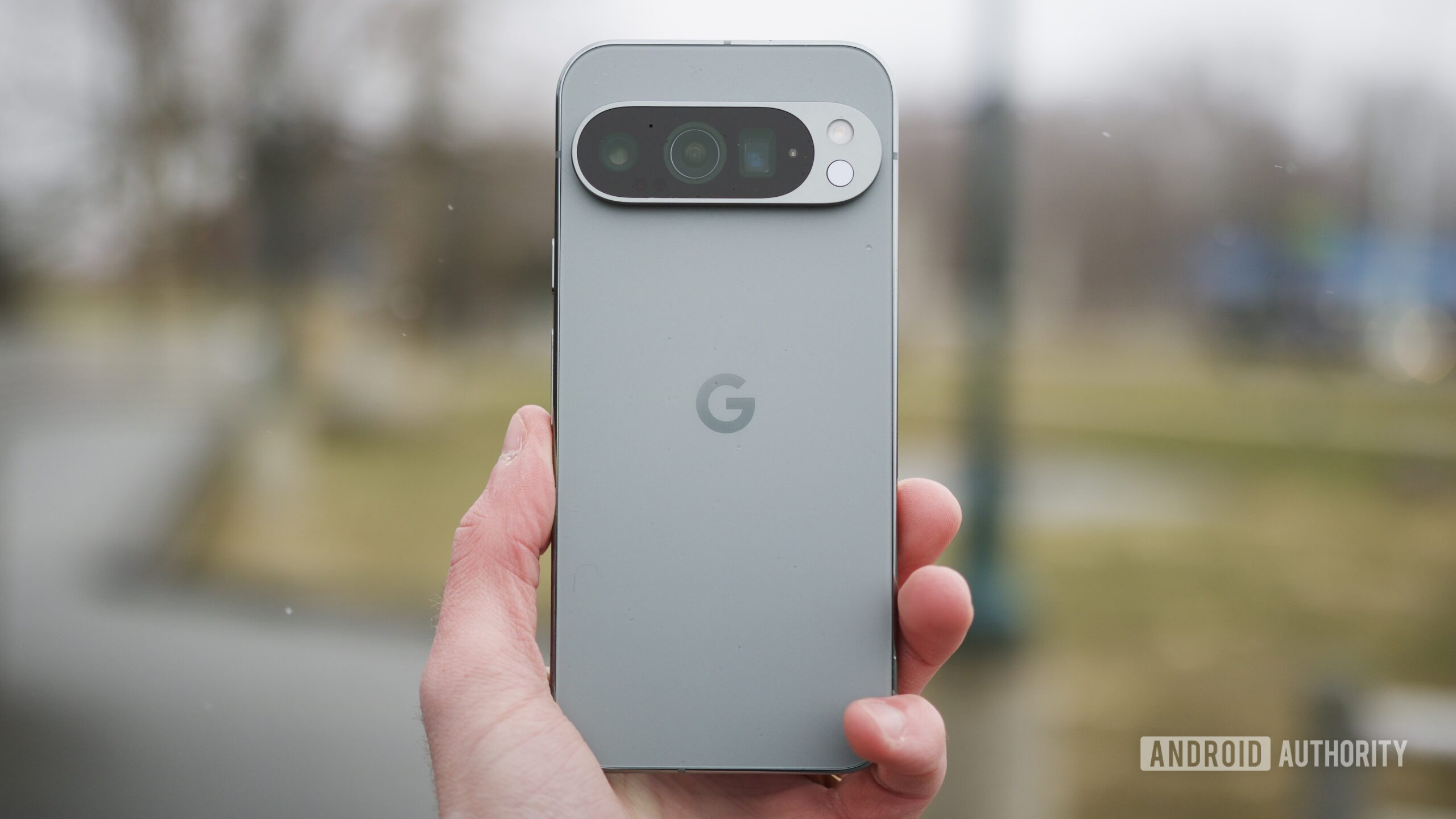 google pixel 9 pro revisit 13 Someone holding the Google Pixel 9 Pro outside.
