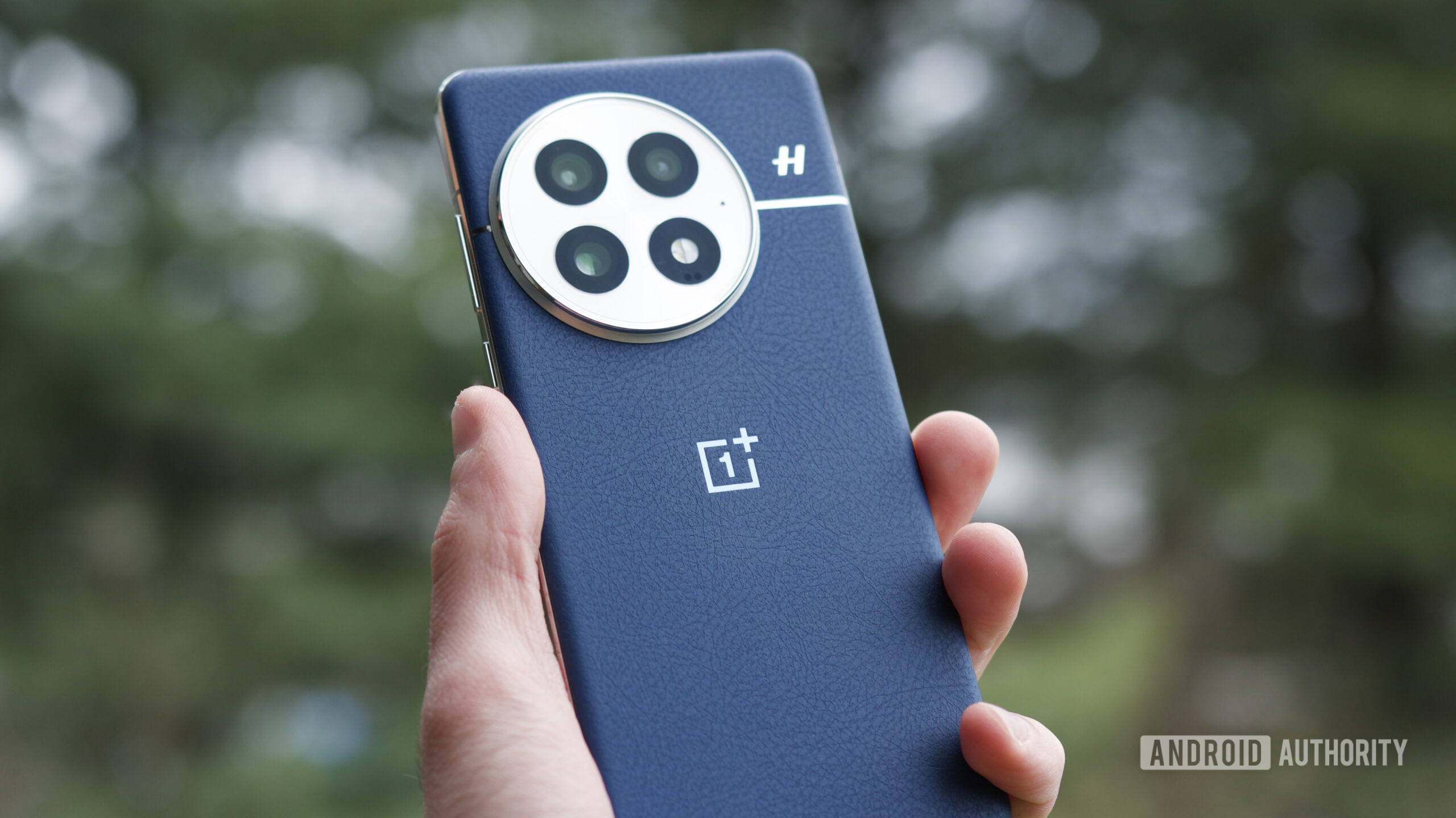 oneplus 13 close up logo phone Someone holding the OnePlus 13 outside.