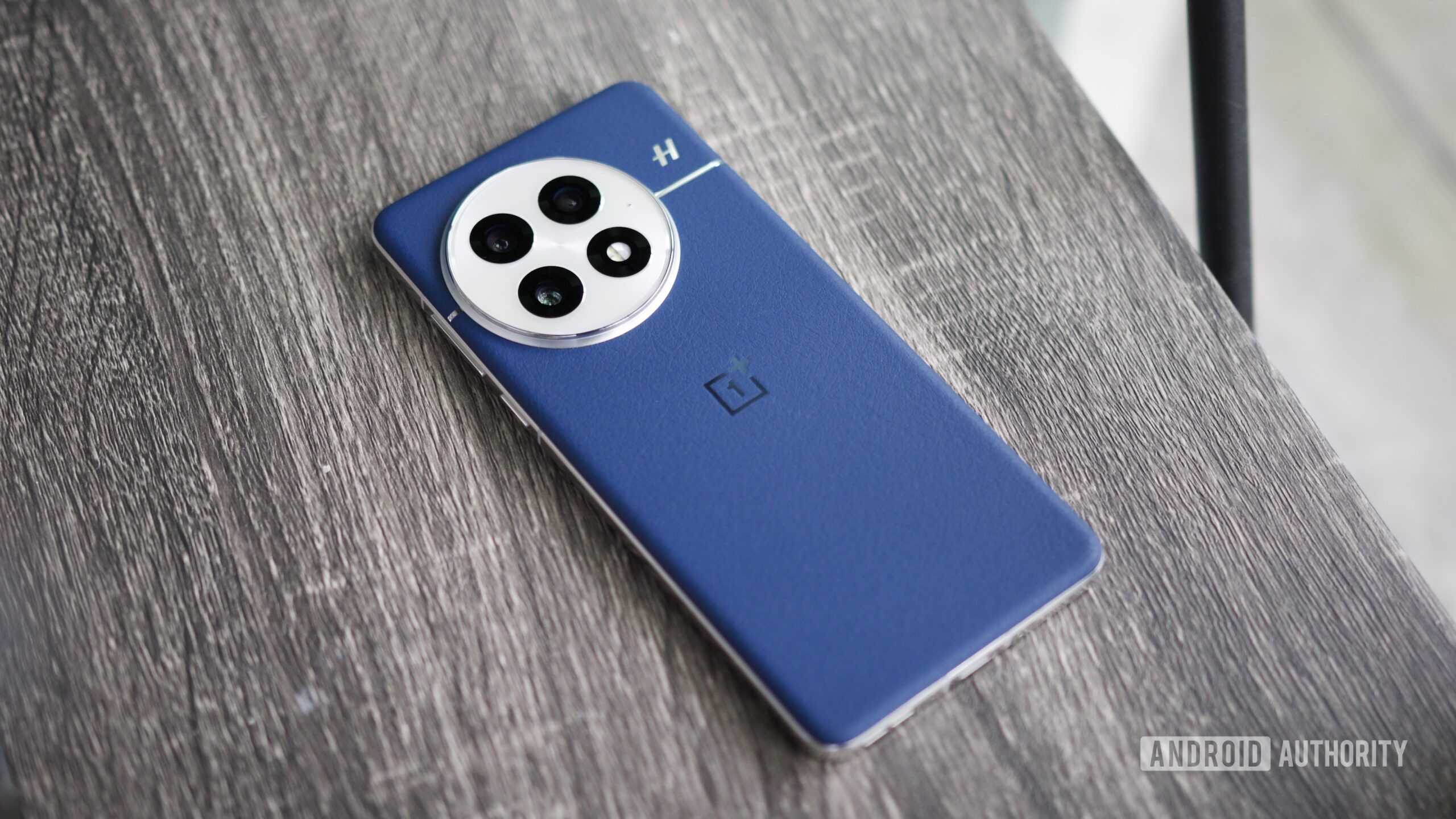 The blue leather OnePlus 13 lying on a shelf.