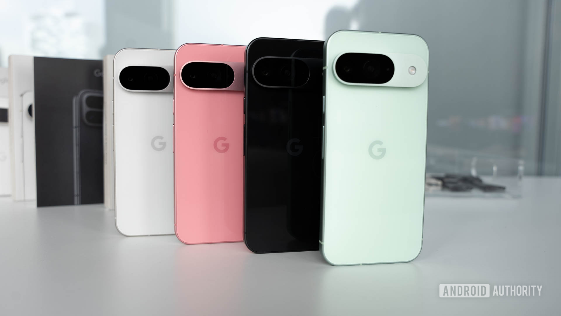 Google Pixel 9 in four colors standing on a table in a row formation Google Pixel 9 in four colors standing on a table in a row formation