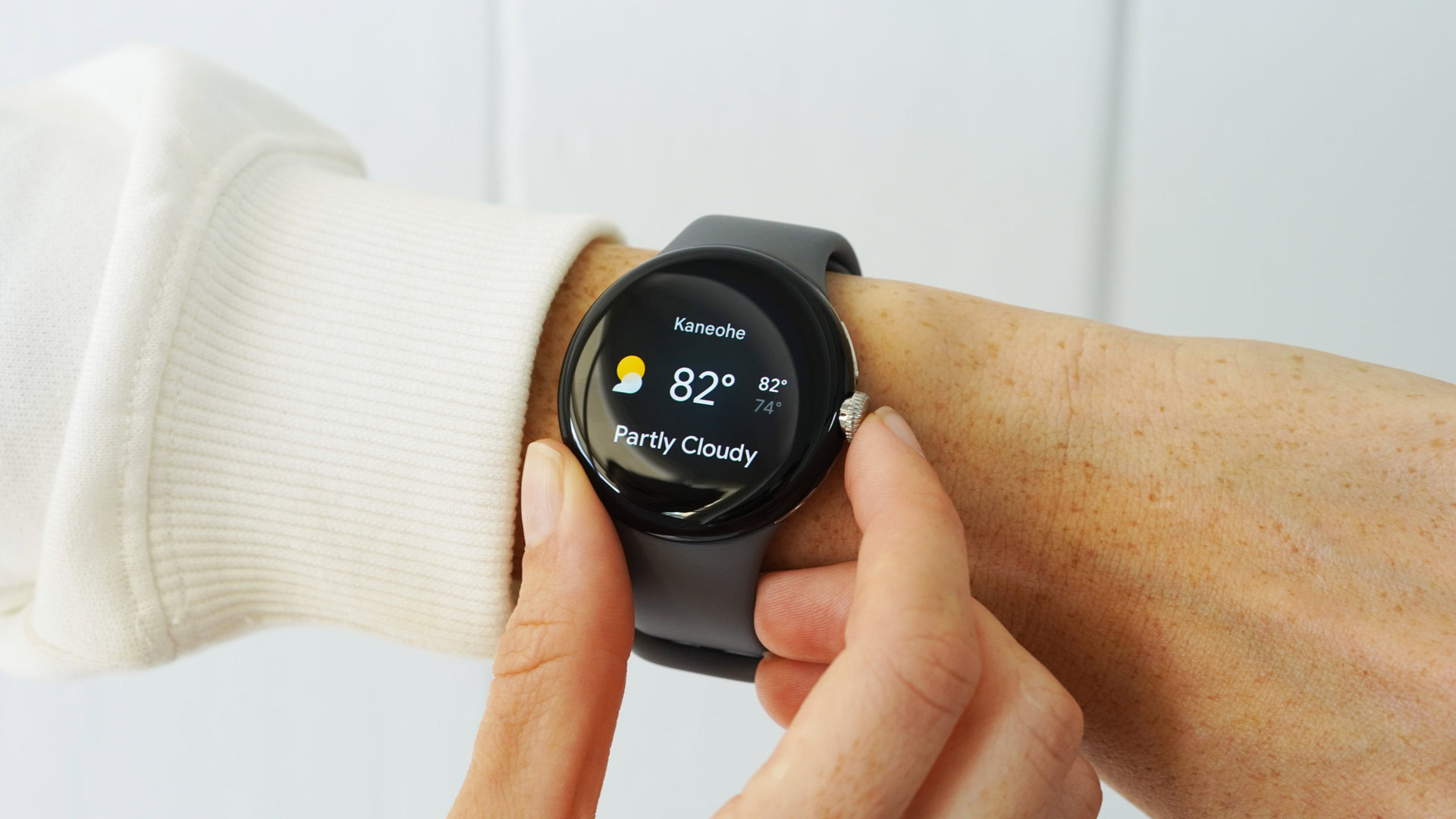 Google Pixel Watch Weather Tile A Google Pixel Watch on a user's wrist displays the Weather tile.