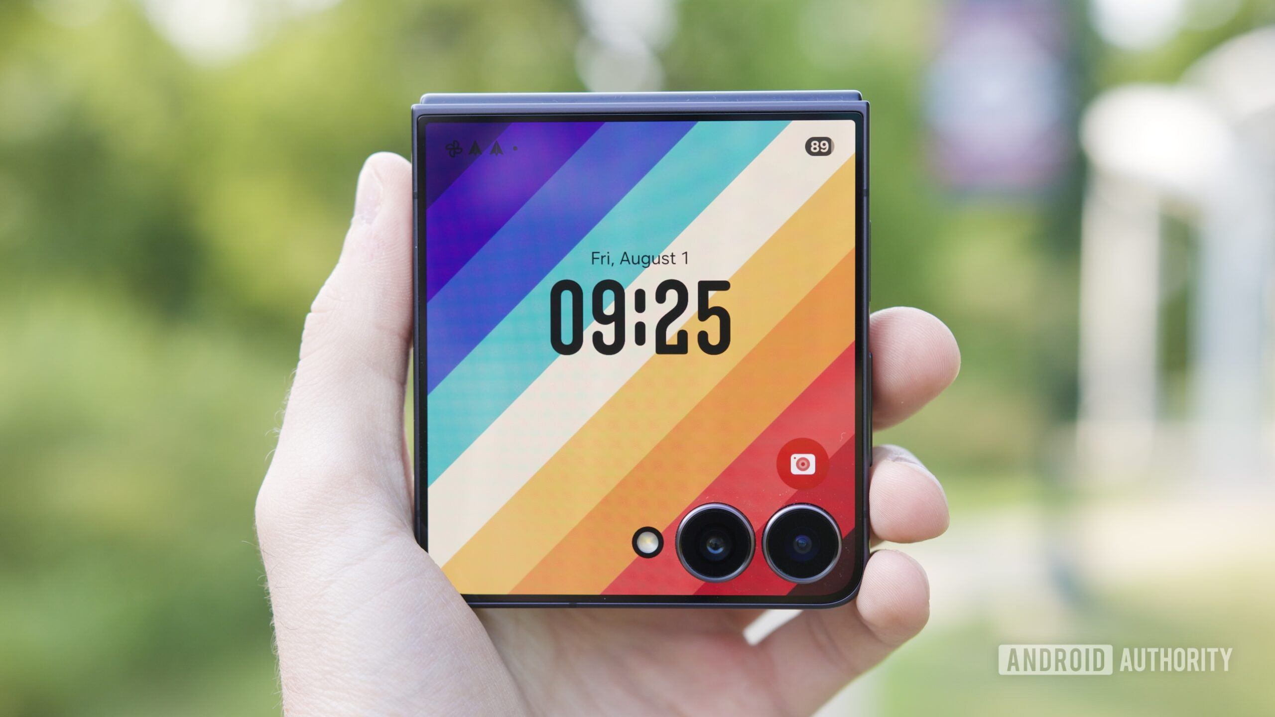 Holding the Galaxy Z Flip 7 with its cover screen on.