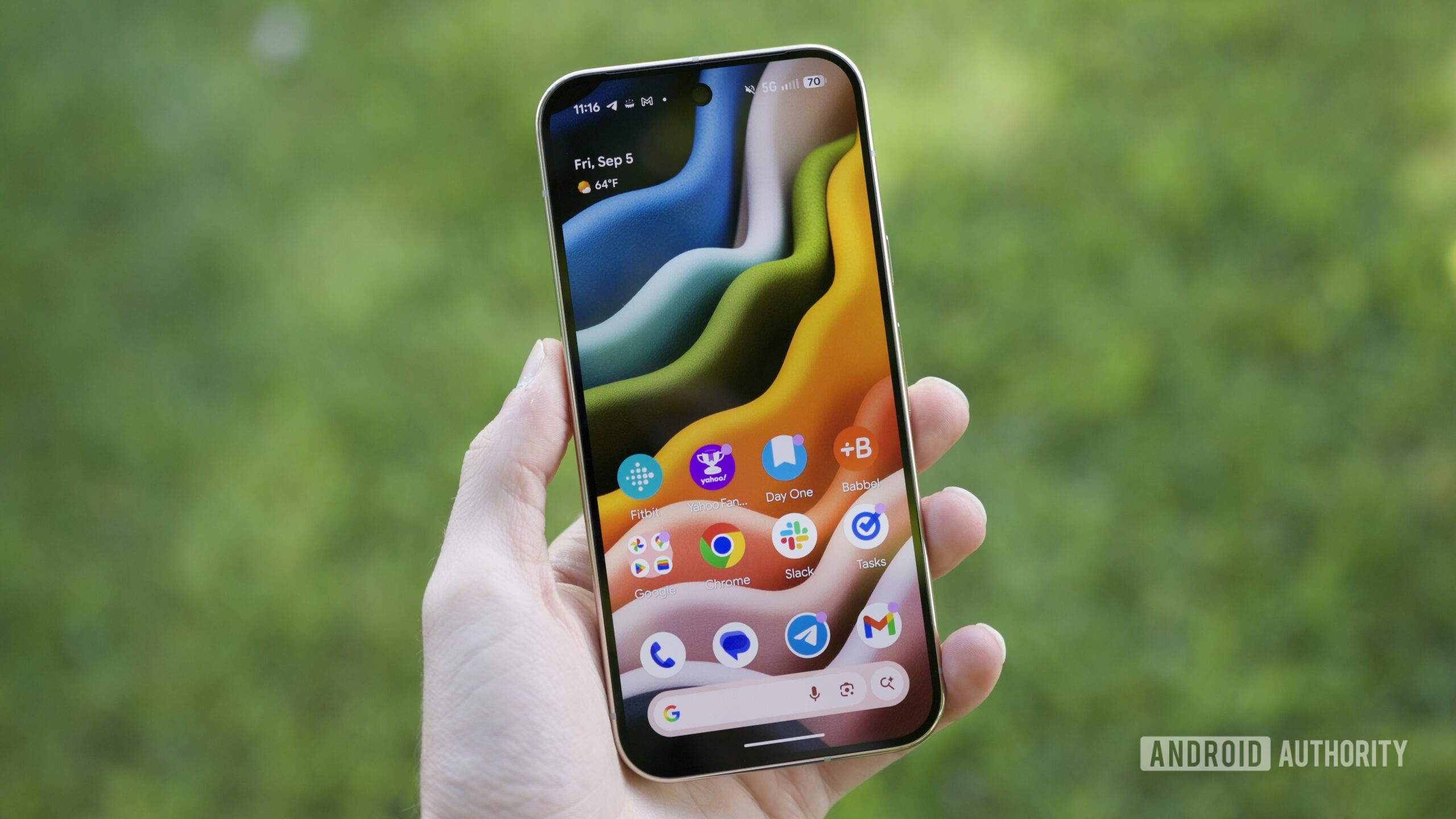 google pixel 10 pro screen on home screen Someone holding the Google Pixel 10 Pro with its screen on, showing the home screen.