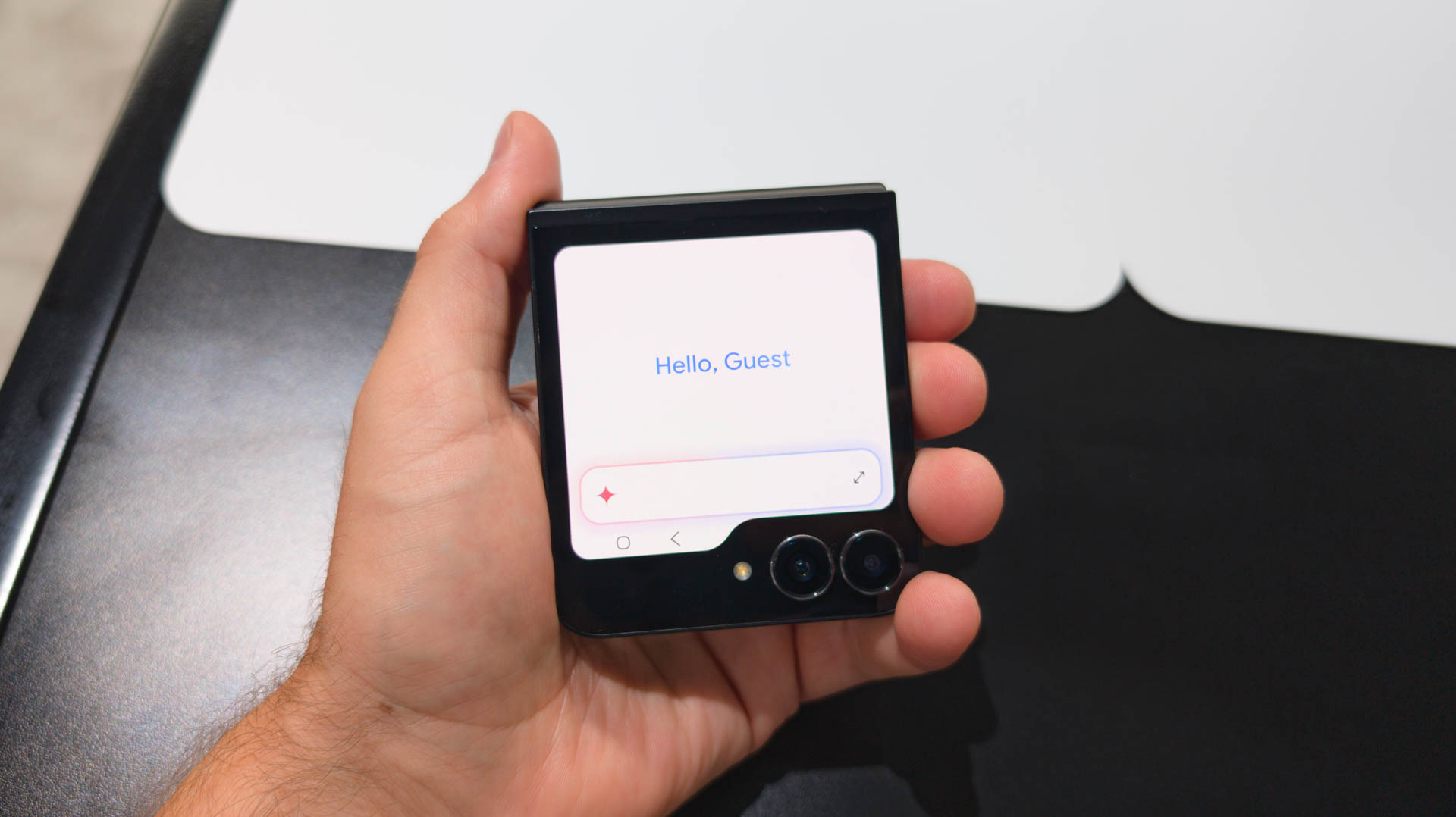 Samsung Galaxy Z Flip 7 FE in Black held in hand with Gemini on cover display