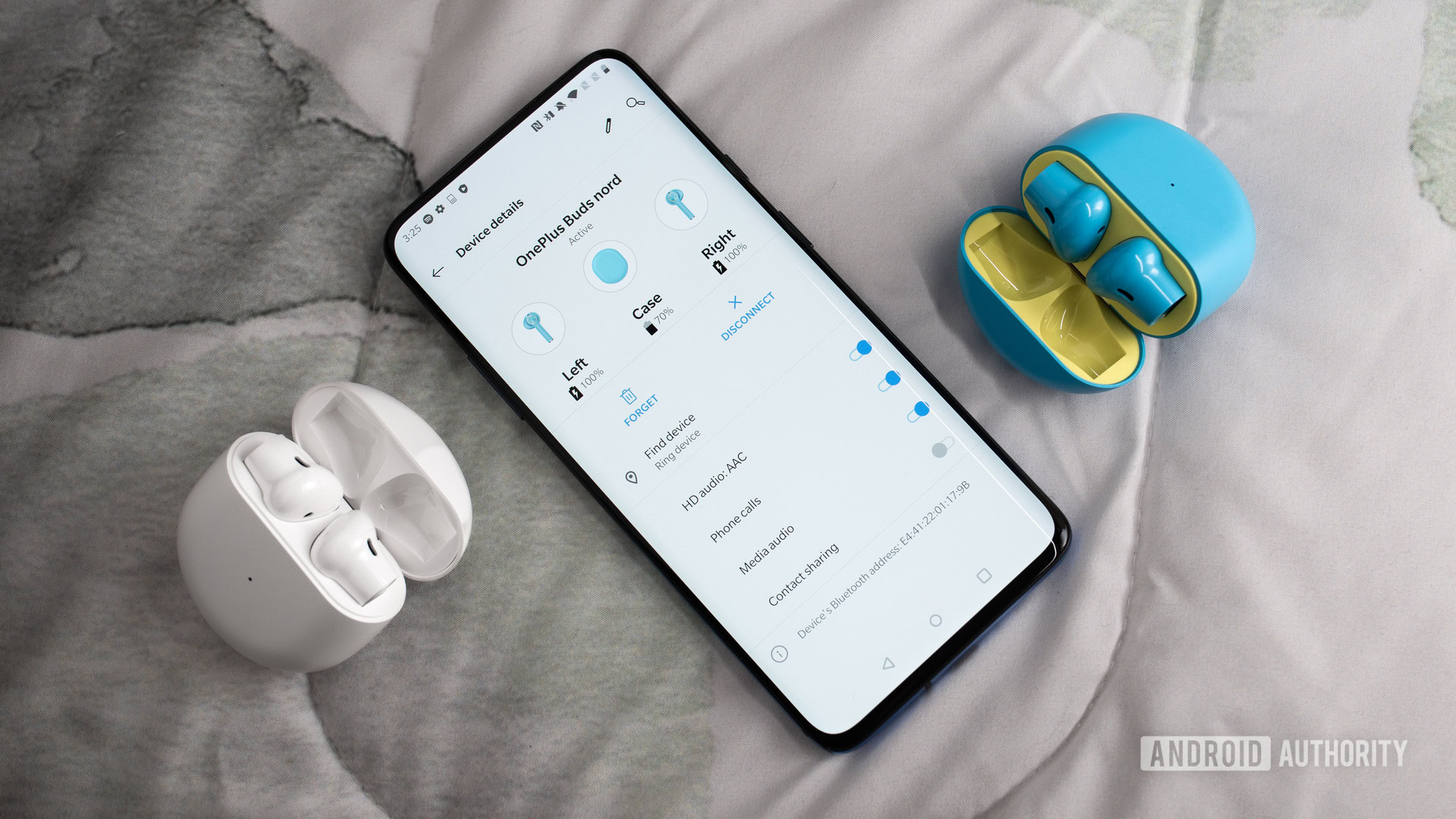 OnePlus Buds Nord Blue White comparison true wireless earbuds case aerial OnePlus 7 Pro smartphone settings A picture of the OnePlus Buds true wireless earbuds in white and Nord Blue next to a OnePlus 7 Pro smartphone with the earbuds menu pulled up on the screen.