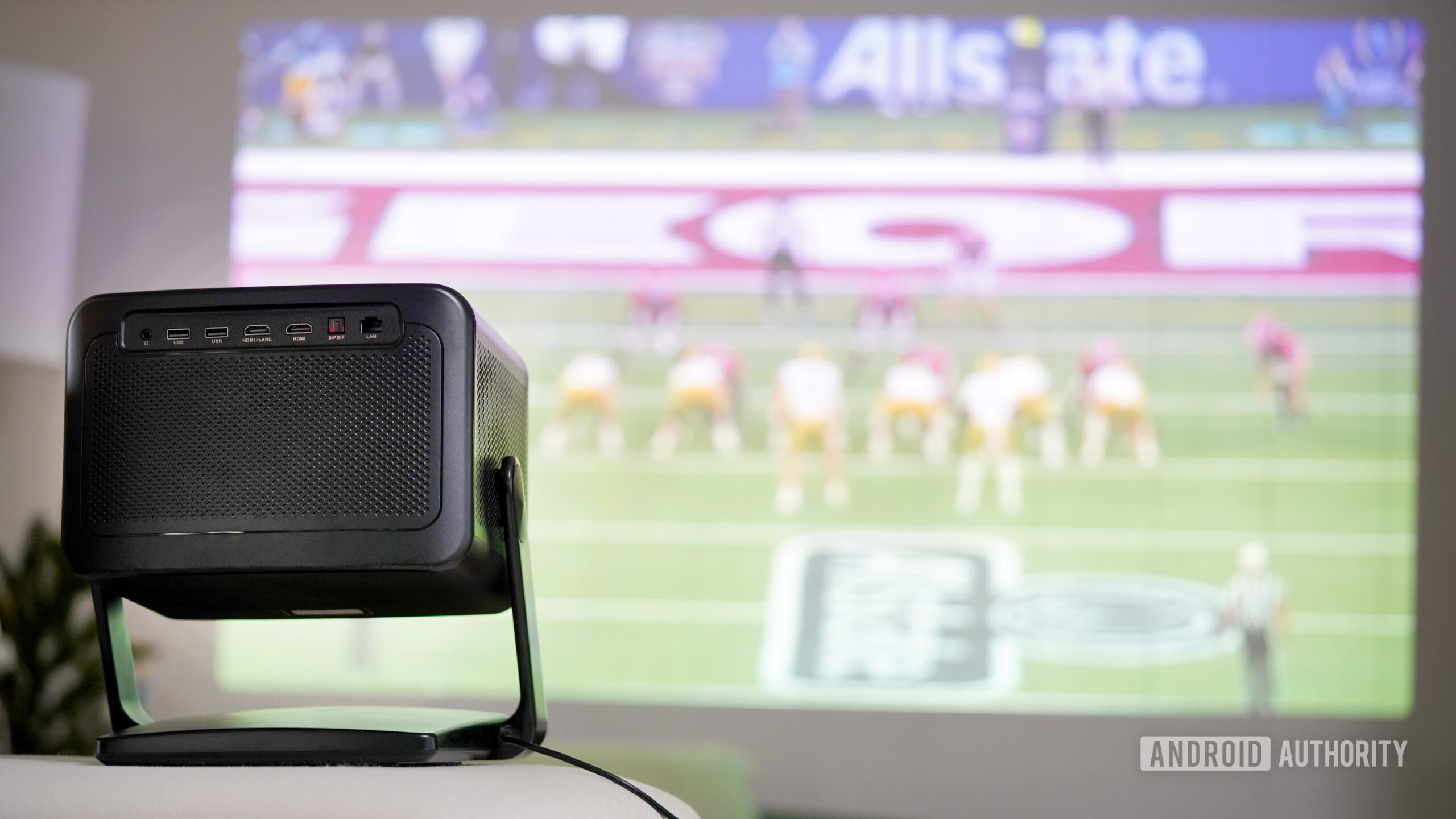 A Dangbei DBOX02 Pro projects a college football game.