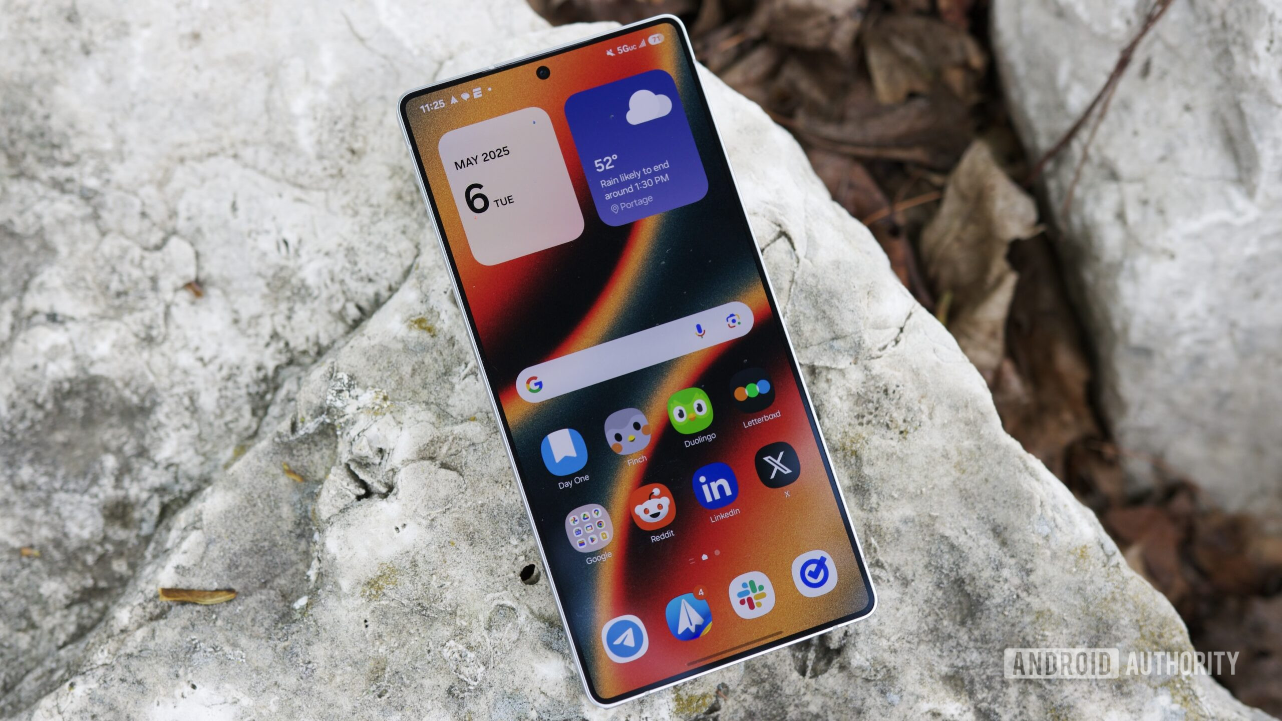 The Samsung Galaxy S25 Ultra laying outside with its display on.